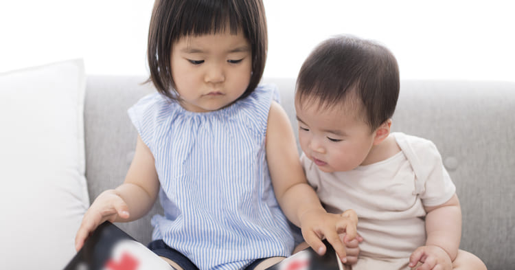 絵本を読む乳児と幼児