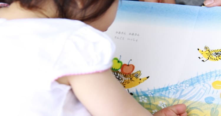 絵本を読む赤ちゃんの背中