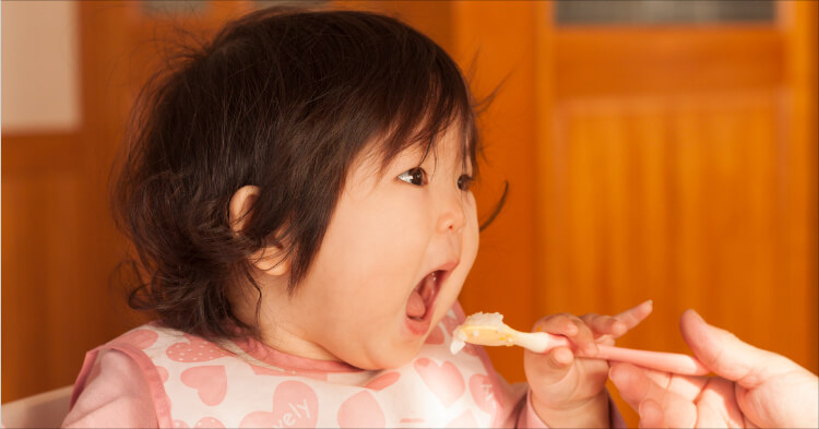赤ちゃんスタイ_ご飯を食べる乳児